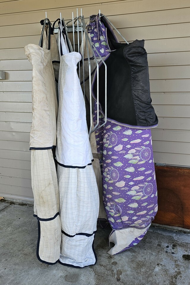 Horse covers hanging on rack outside
