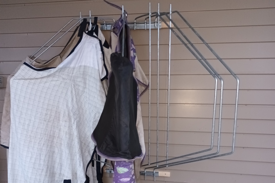 Horse covers on a pivoting cover rack